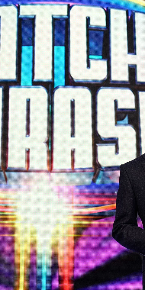Presenter posing in front of the Catchphrase logo.