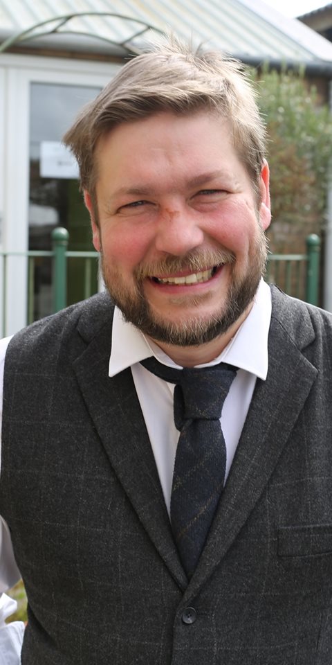 Close up shot of a man smiling at the camera.